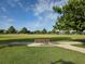 Serene park view featuring a bench, lush green grass, blue sky, and mature trees at 15500 Fountain Cove Ct, Winter Garden, FL 34787