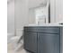 Modern bathroom featuring a gray vanity with a white countertop and framed mirror at 15942 Vetta Dr, Bella Collina, FL 34756