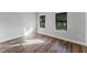 Airy bedroom featuring stylish wood-look flooring and ample natural light from the two windows at 15942 Vetta Dr, Bella Collina, FL 34756