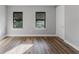 Bright, airy bedroom featuring wood-look flooring, two windows with blinds, and neutral walls at 15942 Vetta Dr, Bella Collina, FL 34756