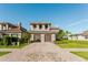 Two-story home featuring a tile roof, two-car garage, and a paver driveway at 15942 Vetta Dr, Bella Collina, FL 34756