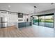 Modern kitchen featuring white cabinets, a gray island, stainless steel appliances, and sliding doors to the backyard at 15942 Vetta Dr, Bella Collina, FL 34756
