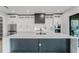 This kitchen features white cabinets, stainless steel appliances, dark gray island, and a modern design at 15942 Vetta Dr, Bella Collina, FL 34756