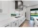 Modern kitchen featuring white cabinets, stainless steel appliances, and views of the outdoor space at 15942 Vetta Dr, Bella Collina, FL 34756