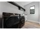 Modern laundry area boasting a black washer and dryer, sleek countertops, and ample storage shelving at 15942 Vetta Dr, Bella Collina, FL 34756