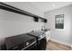 Well-lit laundry room with sleek black washer and dryer, and ample storage with overhead shelves at 15942 Vetta Dr, Bella Collina, FL 34756