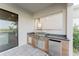 Built-in outdoor kitchen with stainless steel appliances and stone countertops at 15942 Vetta Dr, Bella Collina, FL 34756