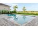 Backyard features a private swimming pool, palm trees, and lush greenery at 15942 Vetta Dr, Bella Collina, FL 34756