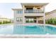 Back exterior with a beautiful inground pool and patio with an outdoor kitchen at 15942 Vetta Dr, Bella Collina, FL 34756