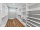 Bright walk-in closet with custom shelving and wood floors provides ample storage space at 15942 Vetta Dr, Bella Collina, FL 34756