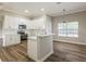 Bright kitchen with white cabinets, stainless steel appliances, and wood-look flooring adjacent to dining space at 1660 Justin Matthew Way, St Cloud, FL 34771