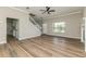 Open-concept living room featuring wood-look floors, natural light, a staircase, and a view to the entry at 1660 Justin Matthew Way, St Cloud, FL 34771