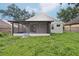 Exterior shot of the screened porch with a view of the grassy backyard at 1802 Waterbeach Ct, Apopka, FL 32703
