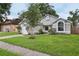 Inviting single-story home featuring a manicured lawn, attached garage, and established landscaping at 1802 Waterbeach Ct, Apopka, FL 32703