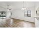 Spacious living room featuring wood-look flooring, natural light, and access to the screened-in porch at 1802 Waterbeach Ct, Apopka, FL 32703