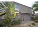 Townhouse exterior showing dark grey paint, stone roof, green bushes, and unit numbers on each door at 1922 Conway Rd # 1922, Orlando, FL 32812