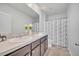 Well-lit bathroom features a double vanity, neutral countertops, and a shower with a decorative curtain at 200 Feltrim Reserve Blvd, Davenport, FL 33837