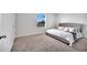 Bright bedroom featuring a comfortable bed, neutral carpeting, and a large window for natural light at 200 Feltrim Reserve Blvd, Davenport, FL 33837