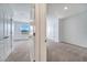 Hallway on the second floor features a view into an open bedroom, neutral carpeting, and paint at 200 Feltrim Reserve Blvd, Davenport, FL 33837