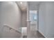 Hallway on the second floor with neutral carpet and paint leading to a room with natural light at 200 Feltrim Reserve Blvd, Davenport, FL 33837