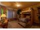Themed bedroom features a wood bunk bed with decor, custom wall textures and decorations, and wood floors at 2041 Lacie Jo Ln, Kissimmee, FL 34743