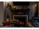 Themed fireplace featuring a stone-look surround, mantel decorations and a cozy lit candle and faux logs at 2041 Lacie Jo Ln, Kissimmee, FL 34743