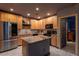 Kitchen featuring stainless steel refrigerator, island, tile backsplash, and decorative themed door at 2041 Lacie Jo Ln, Kissimmee, FL 34743