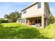 Spacious backyard featuring a covered patio, lush lawn, and neutral-toned exterior on a sunny day at 2071 Remembrance Ave, St Cloud, FL 34769