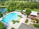 Aerial view of a community pool with lounge chairs, playgrounds, and lush greenery around a lake at 2071 Remembrance Ave, St Cloud, FL 34769