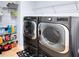 Efficient laundry room with front load washer/dryer set and storage shelving at 2071 Remembrance Ave, St Cloud, FL 34769