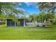 Backyard featuring a screened-in patio, brick patio, lawn, and well-placed palm trees at 209 Wilmer Ave, Orlando, FL 32811