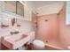 Pink tiled bathroom featuring a walk-in shower and vintage fixtures at 209 Wilmer Ave, Orlando, FL 32811