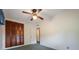 Bright bedroom features a ceiling fan, closet with louvered doors, and doorway to another room at 209 Wilmer Ave, Orlando, FL 32811