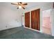 Bedroom features carpet flooring, ceiling fan, and adjacent bathroom and closet at 209 Wilmer Ave, Orlando, FL 32811