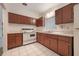Functional kitchen featuring classic wood cabinets, white appliances, and tile flooring at 209 Wilmer Ave, Orlando, FL 32811