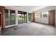 Expansive room featuring sliding glass doors to a patio, ample light, and neutral carpet at 209 Wilmer Ave, Orlando, FL 32811