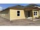 Exterior of a new home showing the side view with a covered patio and bare dirt lot at 2292 Broadbrook Drive, St Cloud, FL 34771