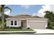 Charming single-story home featuring a two-car garage and a beautifully landscaped front yard with tropical trees at 2292 Broadbrook Drive, St Cloud, FL 34771
