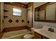 Bathroom featuring tub with custom tile, a mirror, and single sink vanity at 2334 W Doris St, Kissimmee, FL 34741