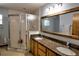 Bathroom featuring double vanity with granite countertop and glass enclosed shower at 2334 W Doris St, Kissimmee, FL 34741