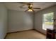 This bedroom features tiled floors, natural light, and a ceiling fan for comfort at 2334 W Doris St, Kissimmee, FL 34741