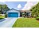 Charming single-story home with a well-maintained lawn, blue trim, and a blue driveway for added curb appeal at 2334 W Doris St, Kissimmee, FL 34741