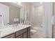Well-appointed bathroom with a combo tub and shower, framed mirror, and wood-tone cabinets at 2338 Lily Bloom Rd, St Cloud, FL 34771