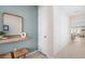 Welcoming entryway featuring decorative mirror, light blue accent wall, white paneled wall and luxury vinyl plank flooring at 2338 Lily Bloom Rd, St Cloud, FL 34771
