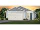 Charming single-Gathering home featuring a two-car garage, craftsman details and lush landscaping against a colorful sunset backdrop at 2338 Lily Bloom Rd, St Cloud, FL 34771