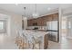 Open concept kitchen with stainless steel appliances, island seating, and seamless connection to the dining area at 2338 Lily Bloom Rd, St Cloud, FL 34771