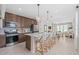 Modern kitchen features an island with bar seating, stainless steel appliances, and a view into the dining and living areas at 2338 Lily Bloom Rd, St Cloud, FL 34771