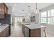 Open-concept kitchen with island seating, pendant lighting, and stainless steel appliances, seamlessly connecting to the living space at 2338 Lily Bloom Rd, St Cloud, FL 34771