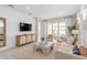 Bright and airy living room featuring stylish furnishings, a TV, and large sliding glass doors with views of the outdoor space at 2338 Lily Bloom Rd, St Cloud, FL 34771