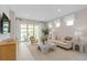 Bright living room featuring neutral color palette, stylish furnishings, and sliding glass doors leading to an outdoor space at 2338 Lily Bloom Rd, St Cloud, FL 34771